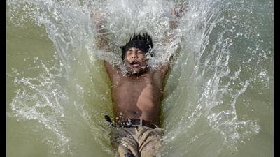 A boy dives into a canal to beat the heat on a hot 1777048590012