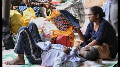 Patients and their attendants sitting under a tin 1777142461479