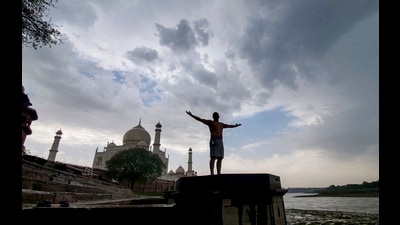 A man stands at Dussehra Ghat on a cloudy day afte 1778252441954