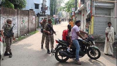 Security forces stand guard near the road leading 1778128502390