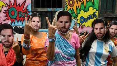 Women wearing masks of Lionel Messi pose for a pho 1782314785740